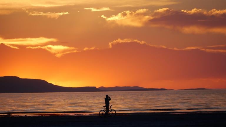 A man on a bike photographs the sunset at the Great Salt Lake Thursday June 13, 2024, near Salt Lake City. (AP Photo / Rick Bowmer)