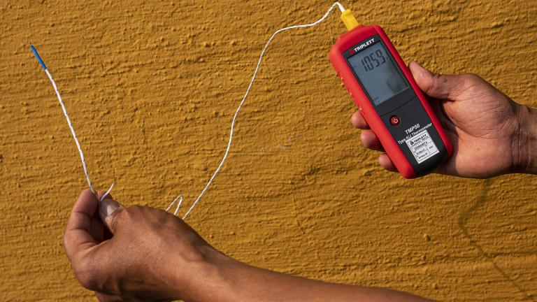 Vivek Shandas, a professor of climate adaptation at Portland State University, takes a temperature reading of almost 106 degrees in downtown Portland, Ore., on Aug. 12, 2021. (Nathan Howard / AP Photo, File)