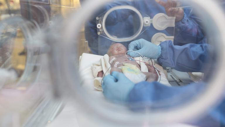 Researchers model the wireless sensors on a doll, alongside a traditional monitoring system composed of electrodes and wires. (Courtesy of Northwestern University)