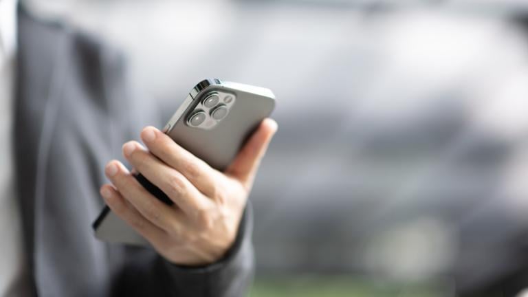 A person holds an iPhone. (Oatawa / iStock)