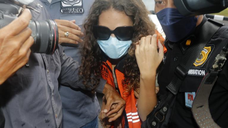 Heather Mack of Chicago, Ill., center, escorted by immigration officers to Immigration detention center in Jimbaran, Bali, Indonesia on Friday, Oct. 29, 2021. (AP Photo/Firdia Lisnawati, File)