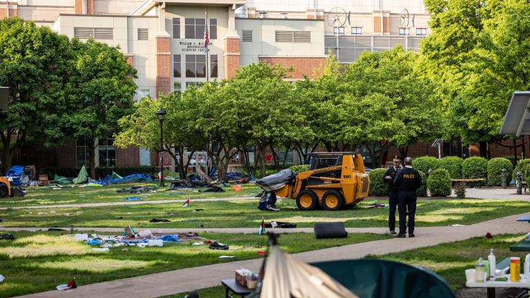 Chicago police personnel keep watch while crews disassemble the pro-Palestinian encampment in the quad at DePaul University's Lincoln Park campus in Chicago, Thursday, May 16, 2024. (Ashlee Rezin / Chicago Sun-Times via AP)