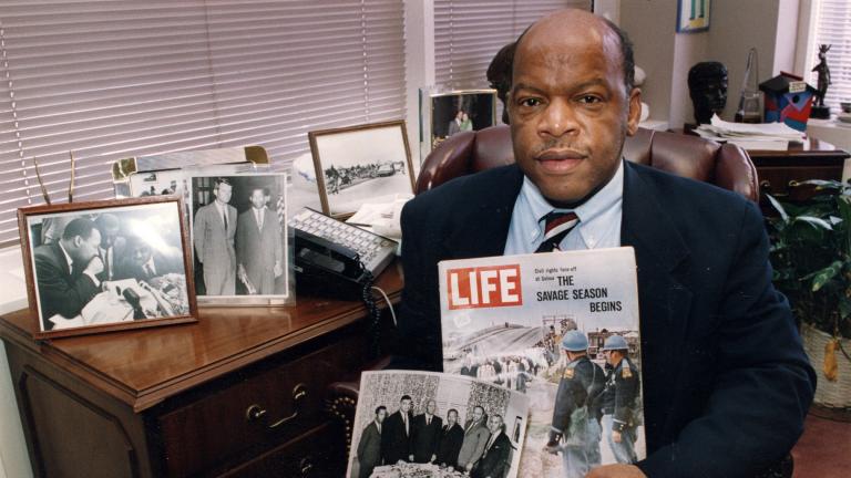 Congressman John Lewis is seen in his Atlanta office with two of his favorite items from his collection of memorabilia from his younger days as a civil rights activist in the 1960s. (Atlanta Journal-Constitution via AP)