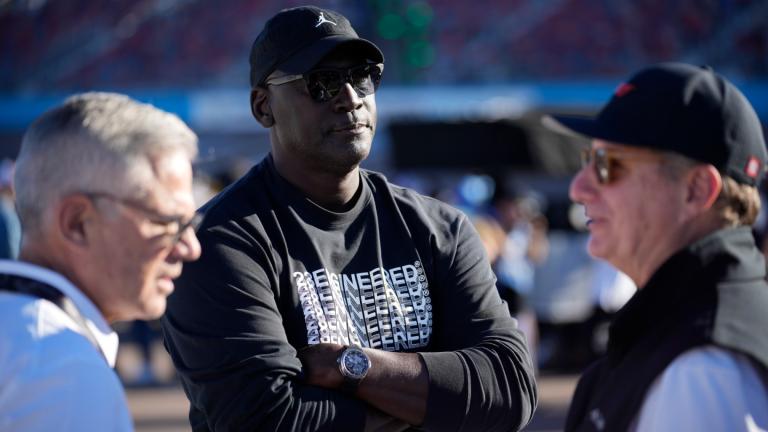 Michael Jordan, center, and Curtis Polk, left, co-owners of 23XI Racing, watch during qualifying beside 23XI Racing President Steve Lauletta, right, for a NASCAR Cup Series Championship auto race, Nov. 9, 2024, in Avondale, Ariz. (AP Photo / John Locher, file)
