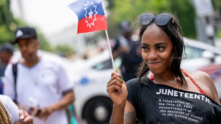 FILE - Chelsea Andrews, of Washington, waves the Juneteenth flag during a Juneteenth celebration at Black Lives Matter Plaza in Washington, Monday, June 19, 2023. (AP Photo / Andrew Harnik, file)