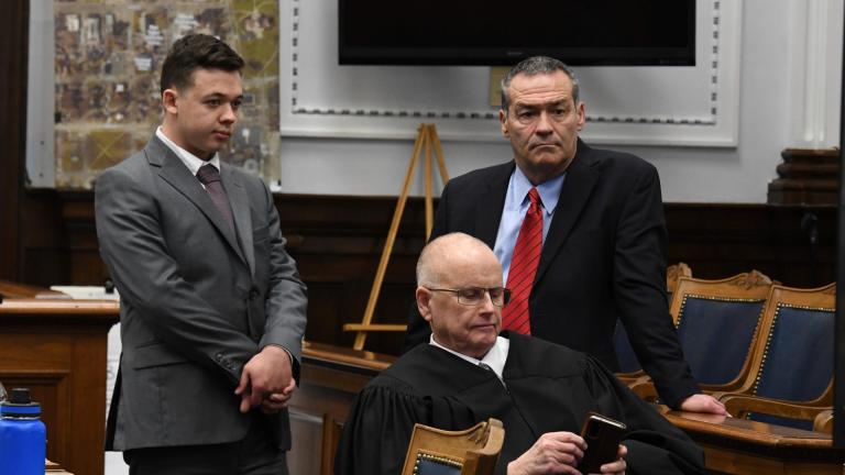 Kyle Rittenhouse and defense attorney Mark Richards stand as Judge Bruce Schroeder makes a personal call during Rittenhouse's trial at the Kenosha County Courthouse in Kenosha, Wis., on Friday, Nov. 12, 2021. (Mark Hertzberg / Pool Photo via AP)