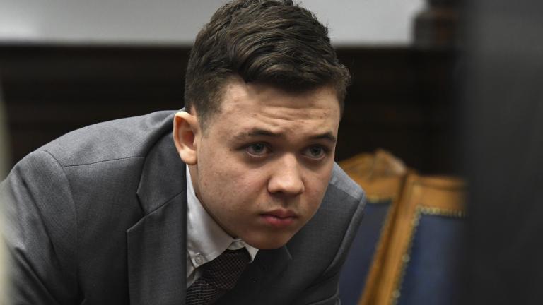 Kyle Rittenhouse peers at the screen as attorneys for both sides argue about a video during Rittenhouse's trial at the Kenosha County Courthouse in Kenosha, Wis., on Friday, Nov. 12, 2021. (Mark Hertzberg /Pool Photo via AP)