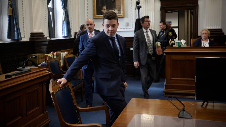 Kyle Rittenhouse, center, pulls out his chair for a meeting Judge Bruce Schroeder called during his trial at the Kenosha County Courthouse in Kenosha, Wis., on Thursday, Nov. 18, 2021. (Sean Krajacic / The Kenosha News via AP, Pool)