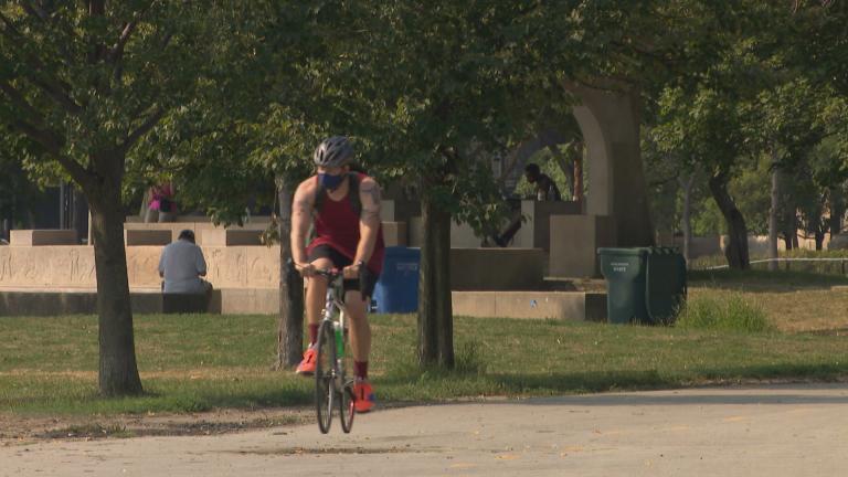 A cyclist wearing a mask rides along the lakefront trail in Chicago. (WTTW News) A cyclist wearing a mask rides along the lakefront trail in Chicago. (WTTW News)