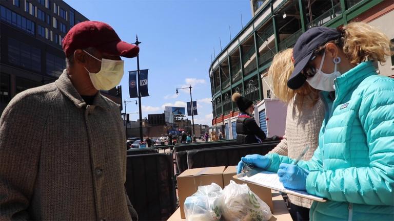 Wiley Alexander, of Chicago, speaks to Lakeview Food Pantry volunteers at Wrigley Field’s temporary food pantry site on April 18, 2020. Alexander says he was laid off amid the COVID-19 pandemic. (Evan Garcia / WTTW News)