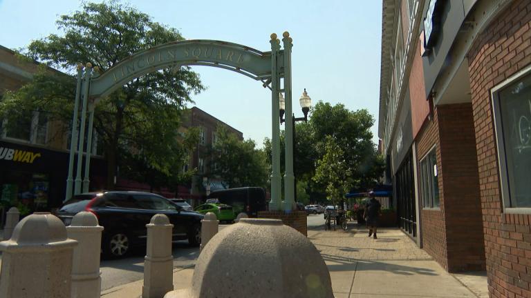 An SUV turns onto Lincoln Avenue from Lawrence Avenue in the Lincoln Square neighborhood in July 2020. The strip is a community hub for shopping and dining. (WTTW News)