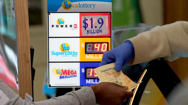 A customer is handed Powerball tickets purchased at Lichine's Liquor & Deli in Sacramento, Calif., Monday, Nov. 7, 2022. Monday night's drawing is estimated to be a record $1.9 billion. (AP Photo / Rich Pedroncelli)