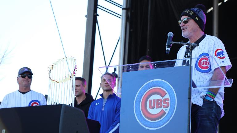Chicago Cubs manager Joe Maddon, standing next to the Commissioner's Trophy, addresses the crowd in Grant Park on Nov. 4, 2016 during the team’s World Series rally. (Evan Garcia / Chicago Tonight)