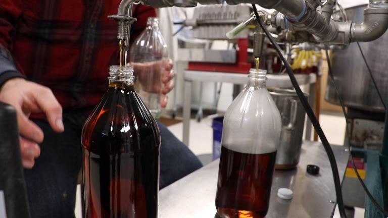 Maple syrup is bottled piping hot in the Funks Grove fishing room. The Funks say the hot liquid sanitizes the container. (Evan Garcia / WTTW News)