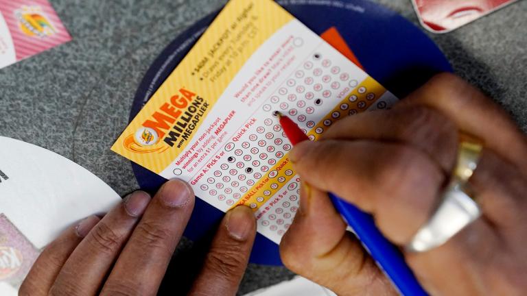 A customer fills out a Mega Millions lottery ticket at a convenience store in Northbrook, Ill., on Jan. 6, 2021. The holiday shopping season, for Mega Millions lottery ticket buyers, at least, is ramping up as officials say the estimated jackpot for the drawing the night of Tuesday, Dec. 27, 2022, has surpassed half a billion dollars. (AP Photo / Nam Y. Huh, File)