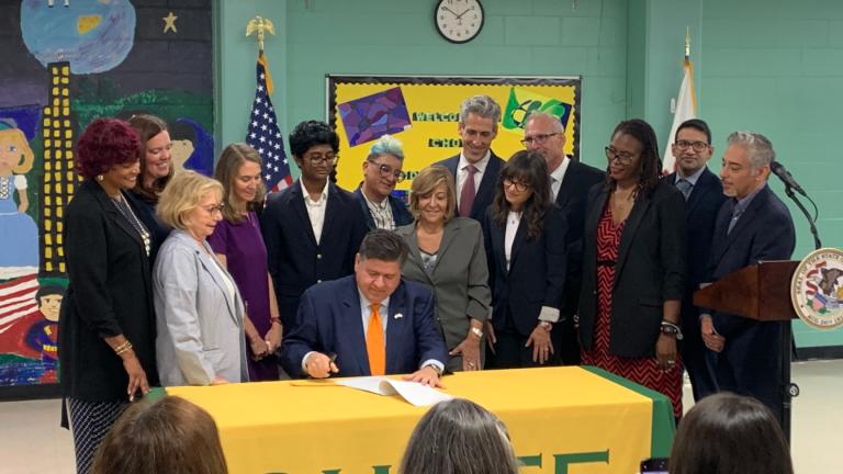 Gov. JB Pritzker signs a law on July 31, 2025, at Chute Middle School in Evanston to implement universal mental health screenings in Illinois schools. (Eunice Alpasan / WTTW News)