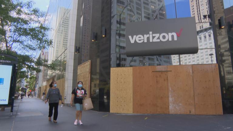 Shoppers walk past a string of boarded-up stores along Michigan Avenue on Friday, Aug. 28, 2020. Shopping along the retail-heavy strip and elsewhere in the city has taken a hit from the pandemic and also recent looting due to unrest. (WTTW News) Shoppers walk past a string of boarded-up stores along Michigan Avenue on Friday, Aug. 28, 2020. Shopping along the retail-heavy strip and elsewhere in the city has taken a hit from the pandemic and also recent looting due to unrest. (WTTW News)