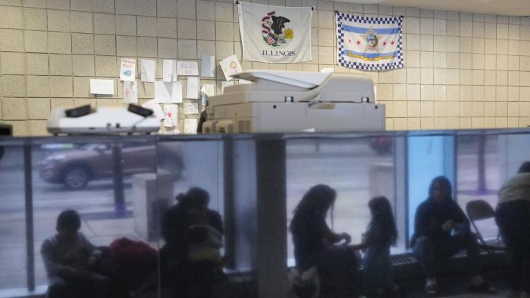 Immigrants from Venezuela are reflected in a marble wall while taking shelter at the Chicago Police Department's 16th District station on Monday, May 1, 2023. In Chicago, where 13,000 migrants have settled in the last year, Mayor Brandon Johnson and Illinois Gov. J.B. Pritzker wrote Homeland Security Secretary Alejandro Mayorkas to ask for parole for asylum-seekers, which, they say, would allow him to get around the wait for a work permit. (AP Photo/Charles Rex Arbogast, FIle)