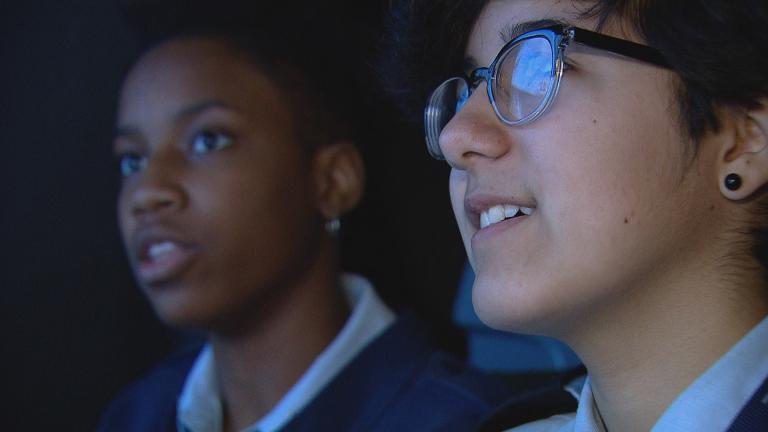 Students Tori Neealy, left, and Leah Nunez in a flight simulator at Air Force Academy High School.