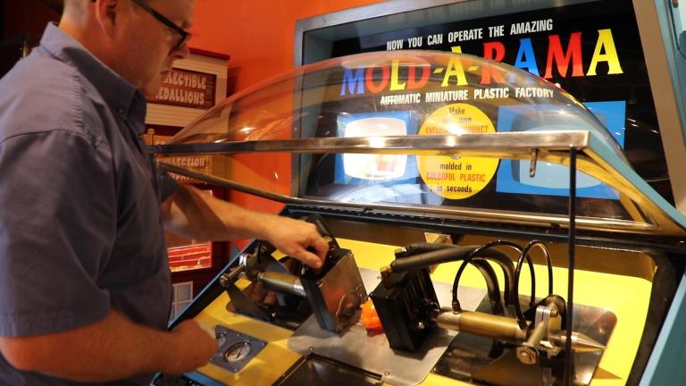 Paul Jones of Mold-A-Rama Inc. checks on a souvenir machine at Lincoln Park Zoo. (Evan Garcia / WTTW News) 