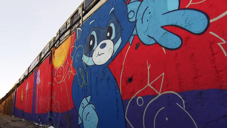 Muralist Nikko Locander, also known as Ali Six, said he wants people to find hope in the 15-foot-high mural “The Butterfly Effect” he created to grace a Wicker Park train embankment. (WTTW News)