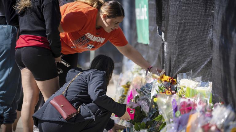 Stacey Sarmiento places flowers at a memorial in Houston on Sunday, Nov. 7, 2021 in memory of her friend, Rudy Pena, who died in a crush of people at the Astroworld music festival on Friday. (AP Photo/Robert Bumsted)