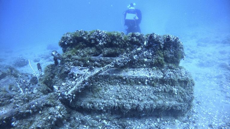 This Aug. 17, 2021, photo shows Quagga mussels cover the engine of a Bell P-39 Airacobra military plane in Lake Huron, Mich., as maritime archaeologist Carrie Sowden, rear, documents the site.(Wayne Lusardi via AP)