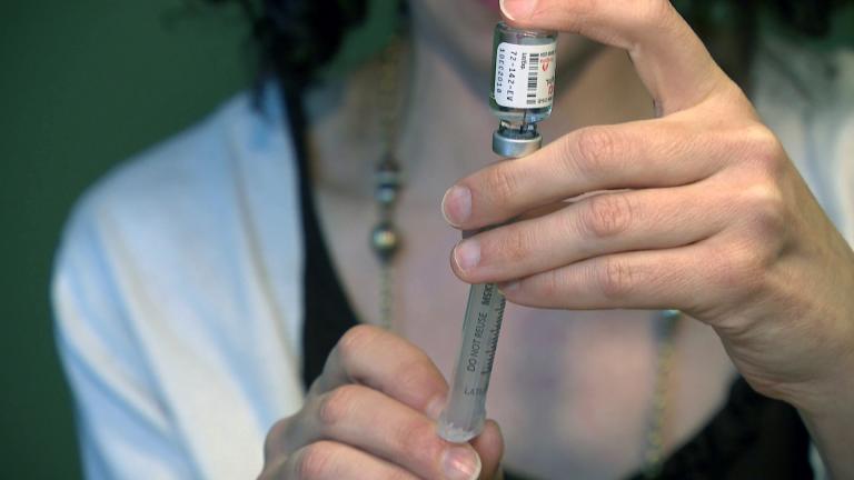 A health care professional draws Naloxone into a syringe. (WTTW News via CNN)