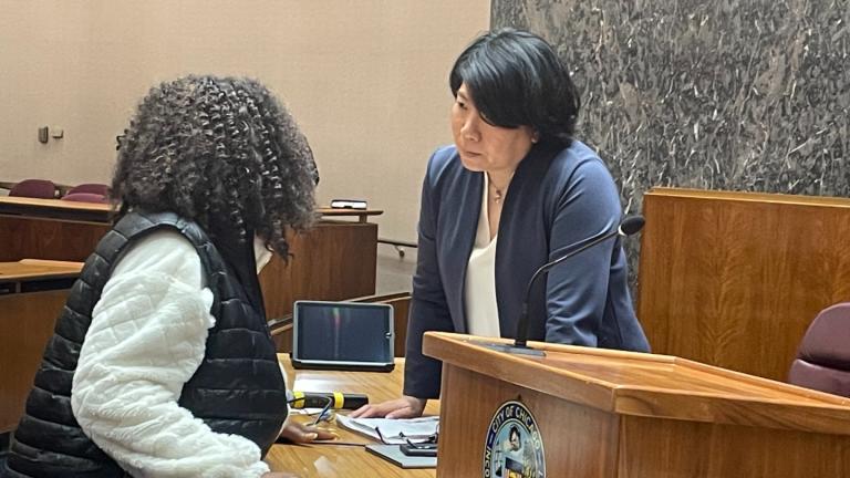 Ald. Nicole Lee, right, speaks with Ald. Emma Mitts before her confirmation by the Chicago City Council on March 28, 2022. (Heather Cherone / WTTW News)