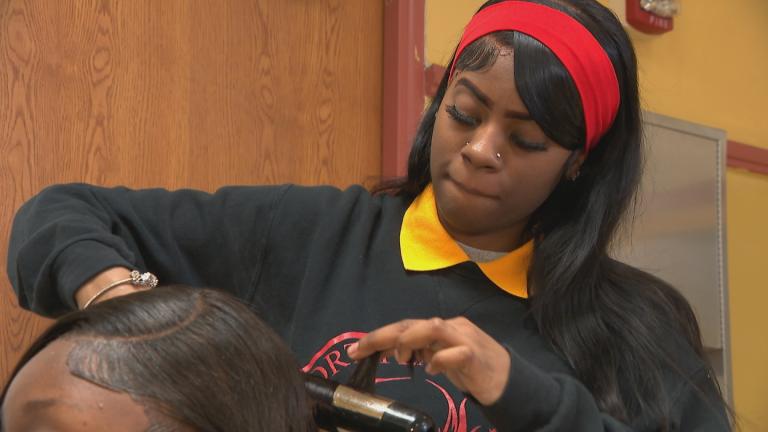 North Lawndale College Prep student Jessica Thurmond styles a classmate's hair. (WTTW News)