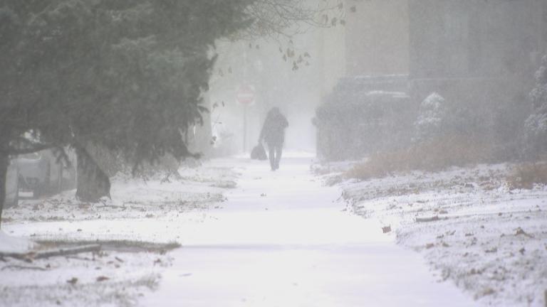 A resident walks down a snowy sidewalk in the North Park area on Dec. 22, 2022. (WTTW News)