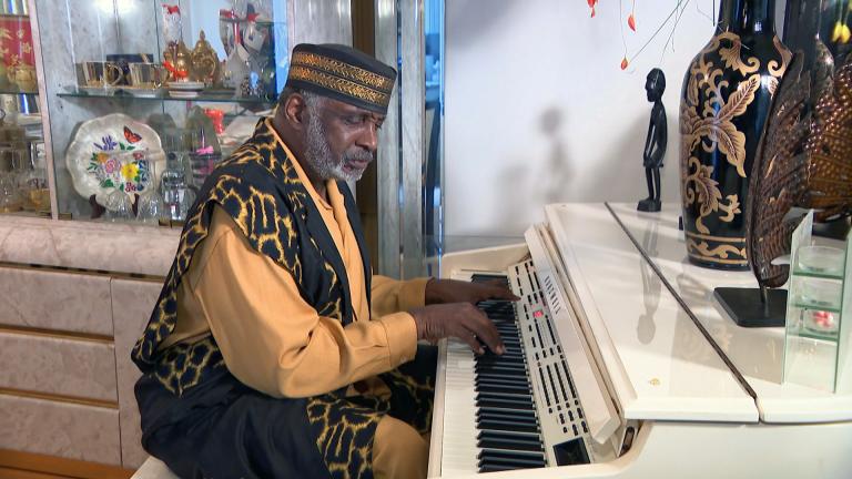 Pastor T.L. Barrett plays piano at his home on July 30, 2021. (WTTW News)