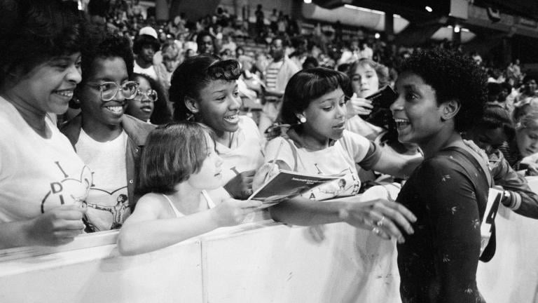 In this June 5, 1983, file photo, Dianne Durham, right, of Gary, Ind., gives autographs after winning the women's title at the McDonald’s U.S.A. Gymnastic Championships at the University of Illinois in Chicago. (AP Photo / Lisa Genesen, File)