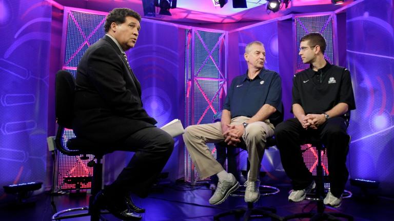 FILE - Greg Gumbel, left, watches as Connecticut head coach Jim Calhoun talks to Butler head coach Brad Stevens, right, prior to taping a television interview for the men's NCAA Final Four college basketball championship game Sunday, April 3, 2011, in Houston. (Eric Gay / AP Photo, File)