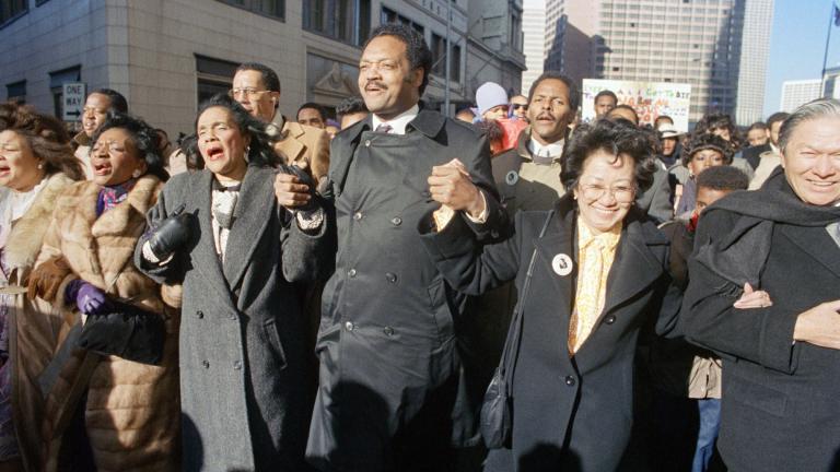 FILE - Coretta Scott King holds hands while singing with the Rev. Jesse Jackson and Christine Farris, the sister of Dr. Martin Luther King, Jr., as they parade on Peachtree Street in Atlanta on Monday, Jan. 19, 1987 to honor King's birthday. At left in Mrs. Alveda king Beall and at right is Lupita Aquino Kashiwahara. (AP Photo / Charles Kelly, File)