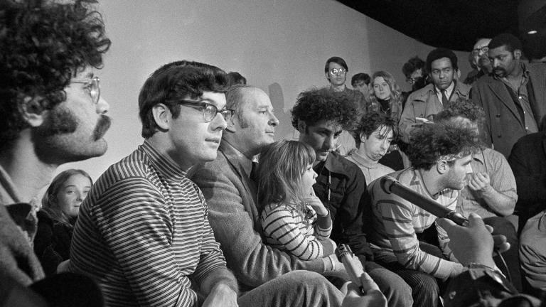 In this Feb. 28, 1970, file photo, the seven defendants in the Chicago Conspiracy Trial hold a press conference in Chicago after the 7th Circuit U.S. Court of Appeals granted their request for bail. Left to right, Lee Weiner, Rennie Davis, David Dellinger, Abbie Hoffman, Tom Hayden, (behind Hoffman), Jerry Rubin and John Froiners. Dellinger holds his granddaughter, Michelle Burd. (AP Photo / JLP, File)