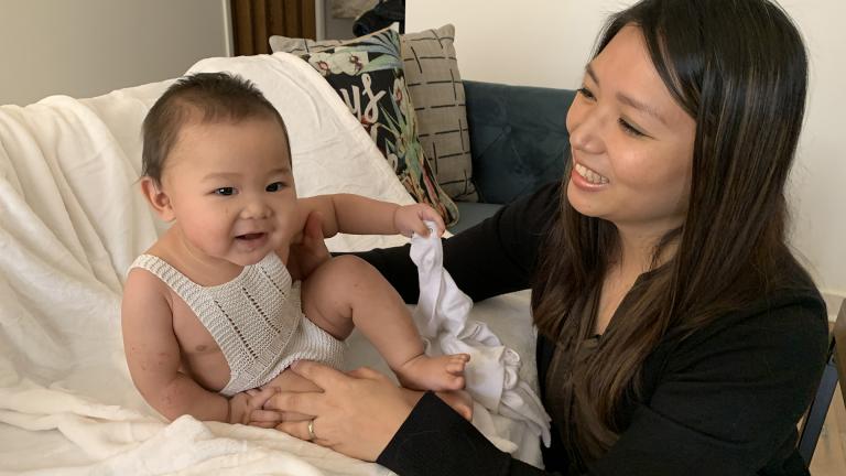 Mary Grace Pingoy and her son Zachary, the most recent member of the Martirez family to wear this hand-crocheted onesie, called a “sunsuit” in the Philippines. (Jay Shefsky / WTTW News)