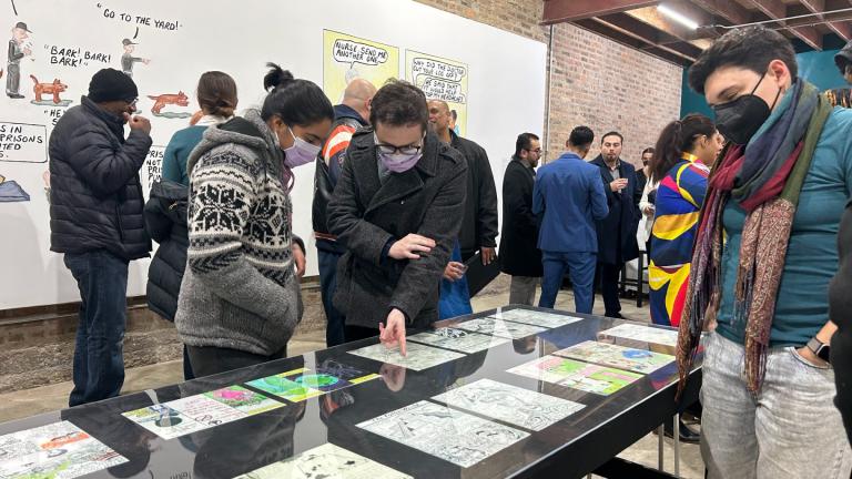 Attendees gather around the drawings of five Prison+Neighborhood Arts/Education Project participants. The organization had a grand opening of its gallery and community space, Walls Turned Sideways, 2717 W. Madison St., on Jan. 27, 2024. (Blair Paddock / WTTW News)