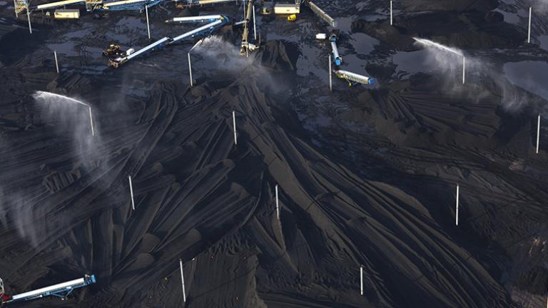 Petcoke piles with sprinklers at KCBX site on Calumet River, 2014. (Terry Evans / Courtesy of Museum of Contemporary Photography)