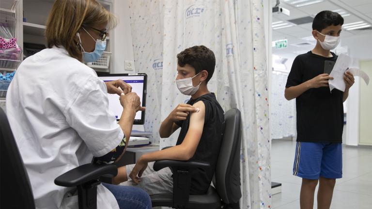 In this June 6, 2021 file photo, a youth receives a Pfizer-BioNTech COVID-19 vaccine in the central Israeli city of Rishon LeZion. (AP Photo / Sebastian Scheiner)