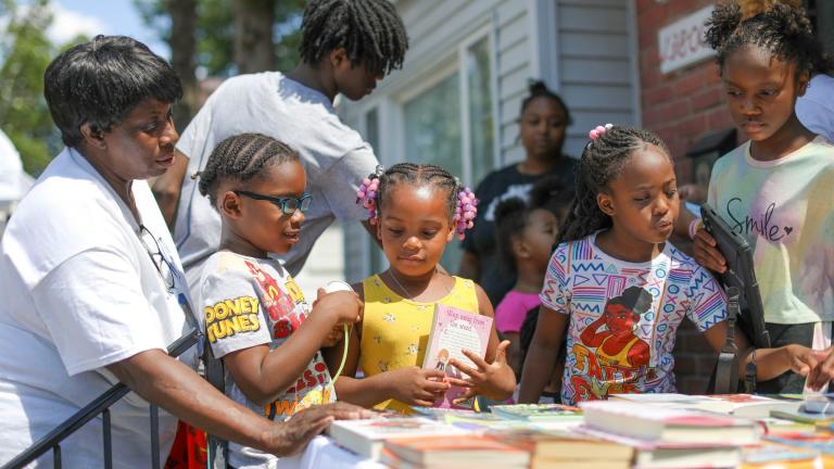 Children take part in Brilliant Detroit's "Street Read" program, where they get to select a book to read to their caregivers or friends outside the nonprofit's Osborn hub in Detroit in 2024. (Brilliant Detroit via AP)