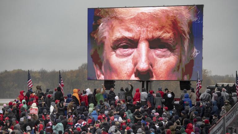 Supporters of President Donald Trump watch a video screen showing his face during a campaign event on Tuesday, Oct. 27, 2020, in Lansing, Mich. (Nicole Hester / Mlive.com - Ann Arbor News via AP)
