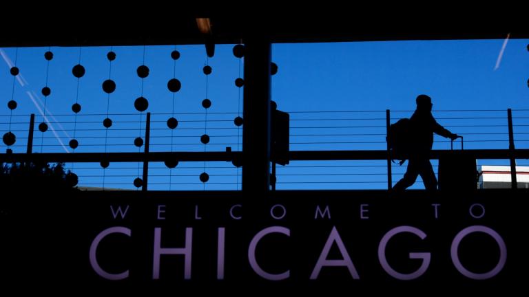 A passenger walks with luggage past holiday decorations at Chicago O’Hare International Airport, Dec. 24, 2022, in Chicago. (AP Photo / Paul Beaty, File)