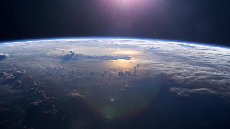 This view of Earth's horizon as the sun sets over the Pacific Ocean was taken by an Expedition 7 crew member onboard the International Space Station (ISS). Anvil tops of thunderclouds are also visible. (NASA)