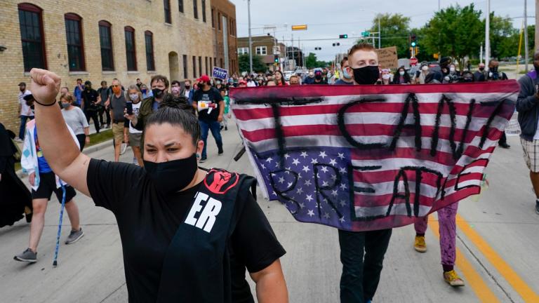 A protester holds a flag during a Black Lives Matter march Tuesday, Sept. 1, 2020, in Kenosha, Wis. (AP Photo / Morry Gash)