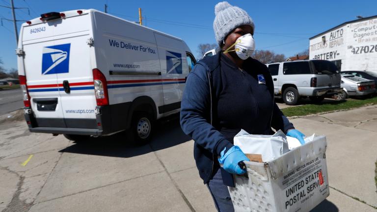 In this April 2, 2020 file photo, a United States Postal Service worker makes a delivery with gloves and a mask in Warren, Mich. I(AP Photo / Paul Sancya, File)