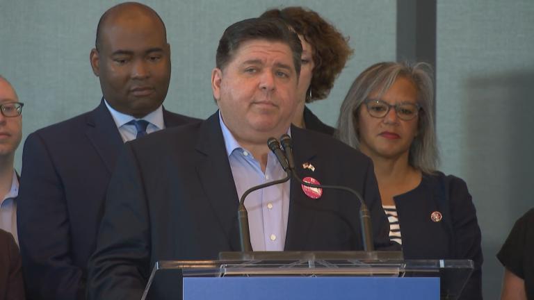 Gov. J.B. Pritzker speaks as Illinois Democrats make their pitch to the national party while U.S. Rep. Robin Kelly, right, looks on. (WTTW News)