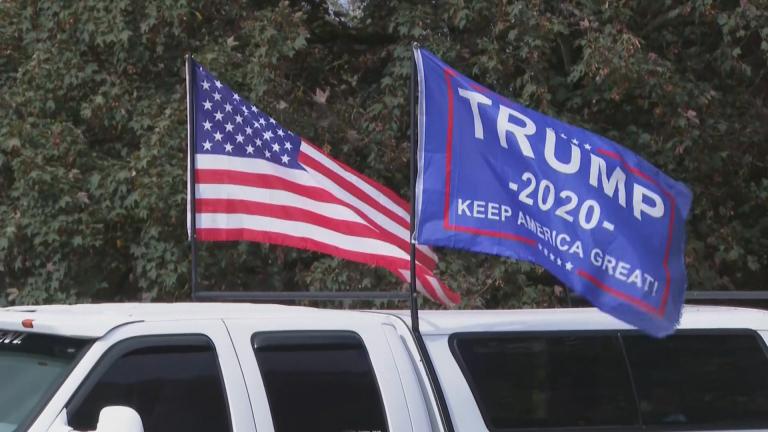 An American flag and Trump campaign flag fly at a Proud Boys rally. (WTTW News via CNN)