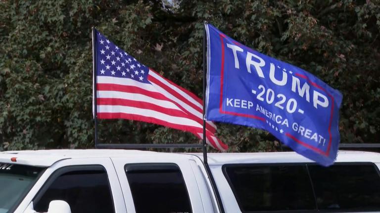 An American flag and Trump campaign flag fly at a Proud Boys rally ahead of the 2020 presidential election. (WTTW News via CNN)