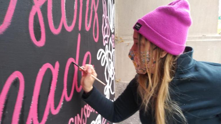 Artist Cristina Vanko hand-letters a Ruth Bader Ginsburg quote on a mural Sunday, Oct. 25, 2020. (Annemarie Mannion / WTTW News)